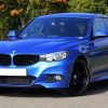 Blue Bmw Sedan Near Green Lawn Grass